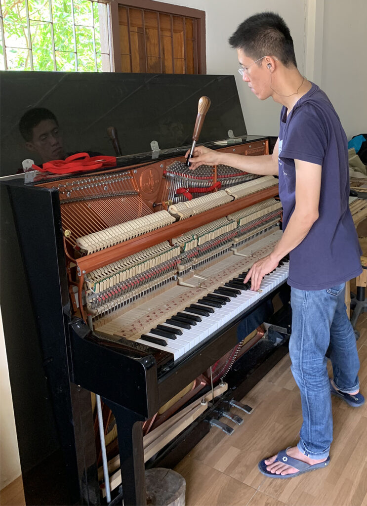 Shin tuning one of the pianos