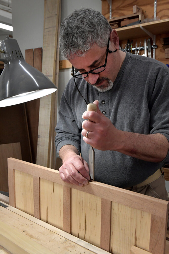 Dan working on his toolbox using a chisel