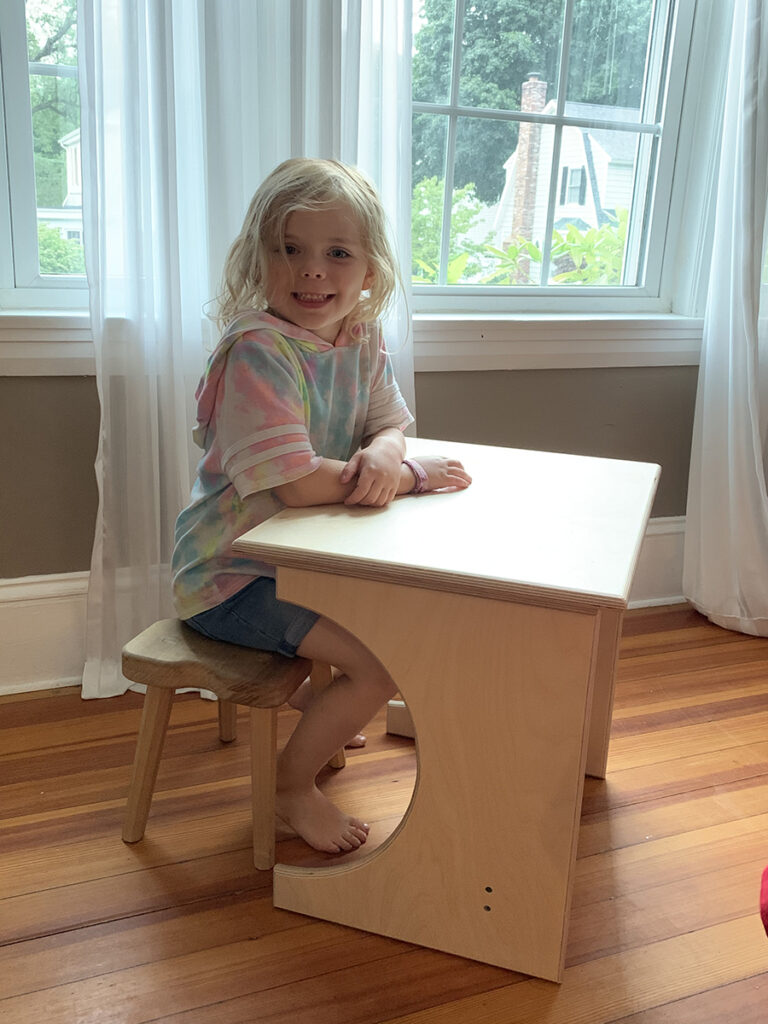 Mike's daughter tries out one of the desks
