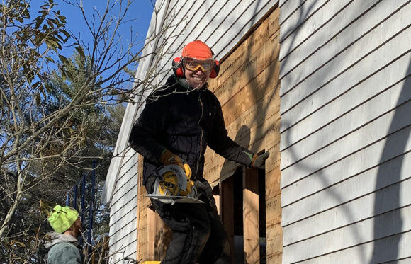Jason McKenzie working on the side of a house