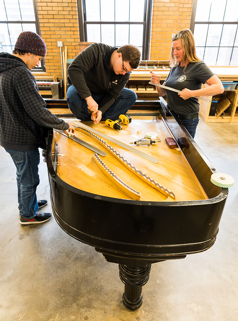 Students rebuilding the piano's bridge