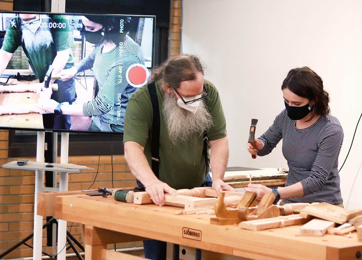 Woodworking instructor and student using a screen projection