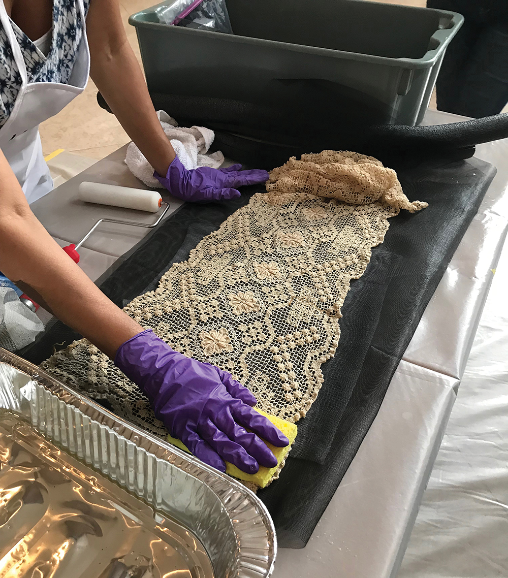 A conservator demonstrates how to salvage a fragile wet textile during HEART. Photo by Stacy Bowe/ Smithsonian Institution.