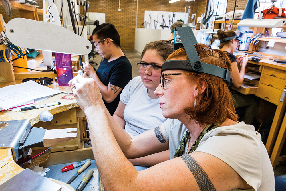 Ann Cahoon working with a jewelry making student
