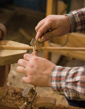 Kinnane shaves down beams for a set of Windsor chairs. Photograph by Marianne Lee