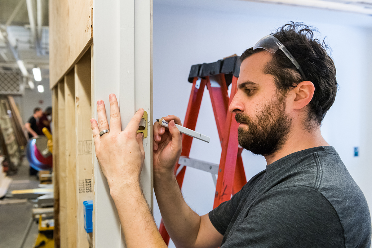 Student installing door hardware