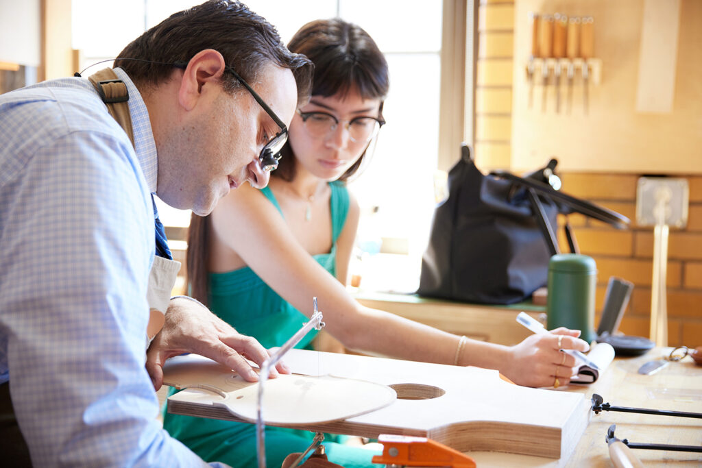 Violin Making student cutting f holes with Instructor Roman Barnas