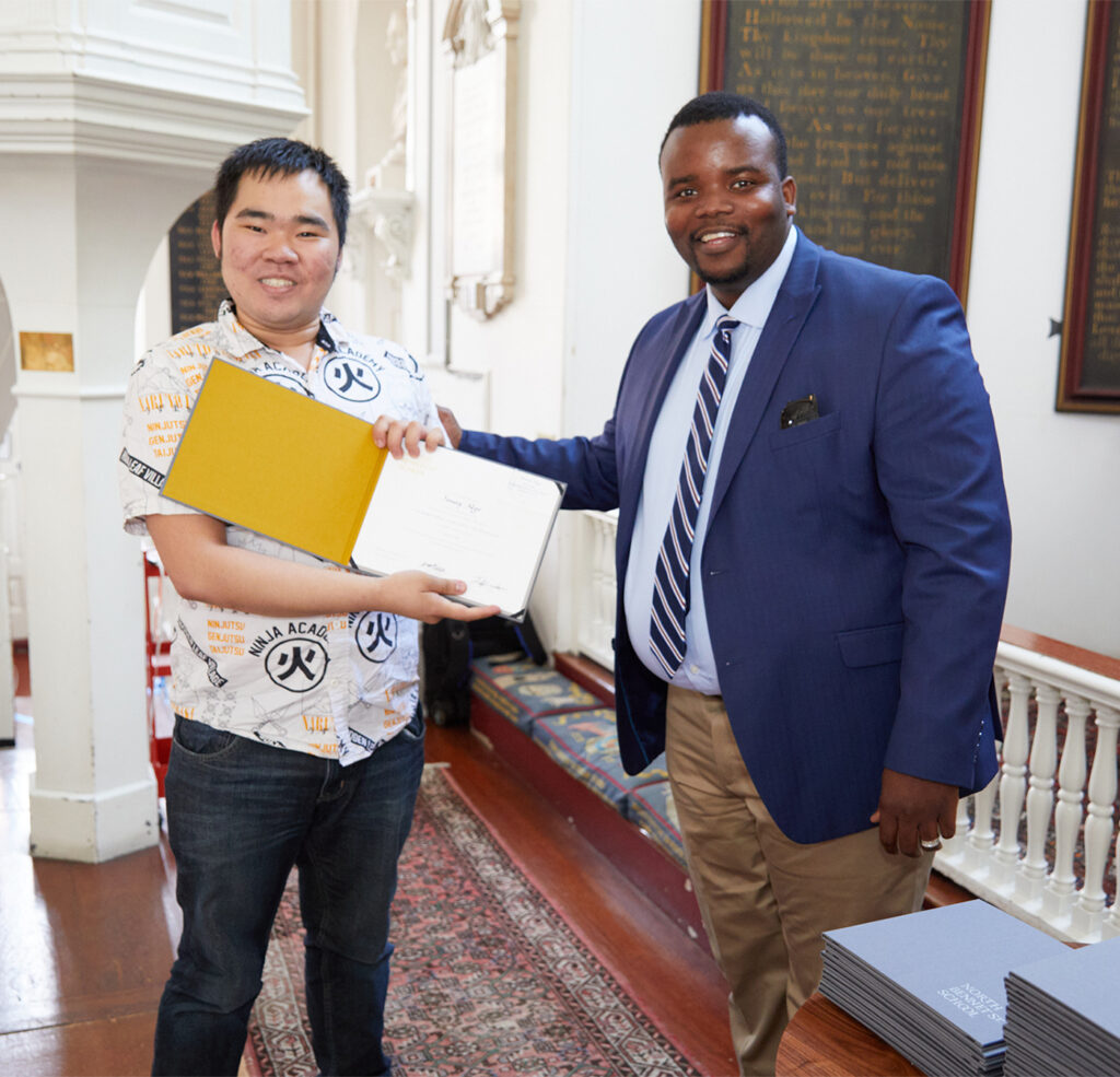 Sonny receiving his diploma at Graduation from Department Head Eddy Dacius