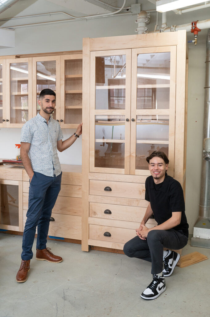 Carpentry students Omar and Cal with the cabinets they built