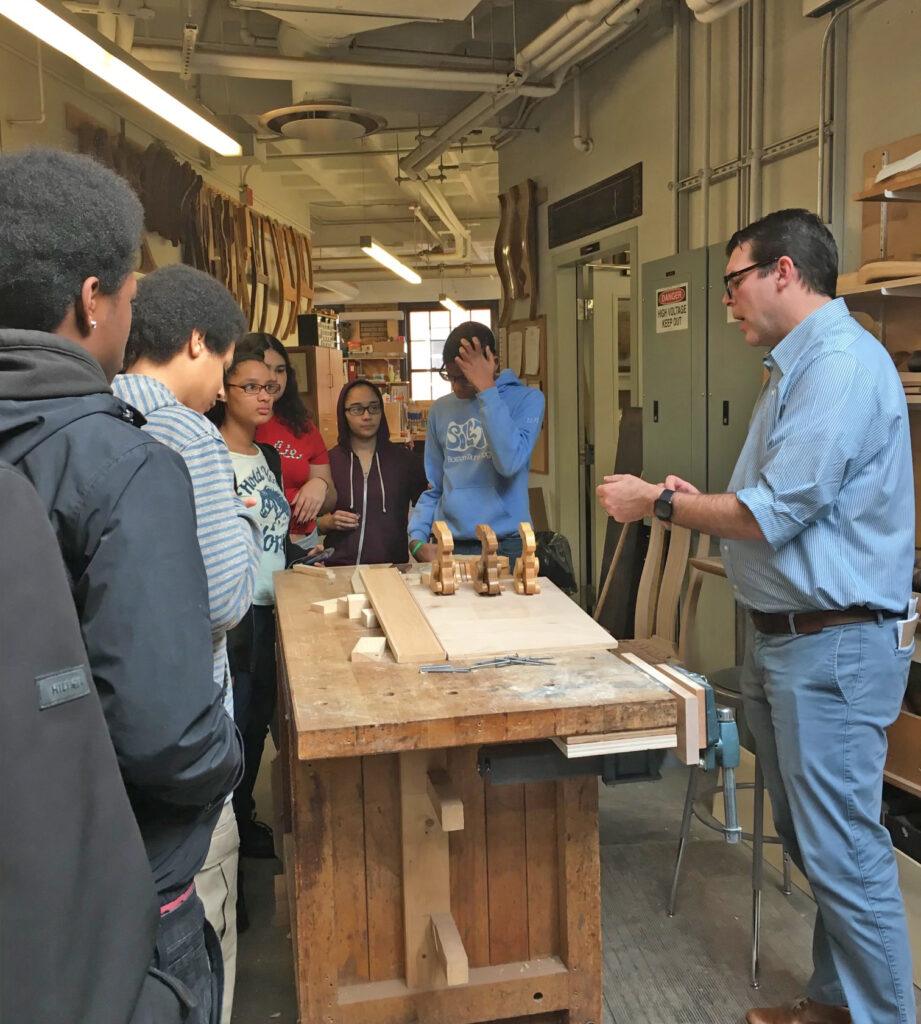 Admissions Director Rob O'Dwyer giving a tour of the Cabinet & Furniture Making program to Project REACH students