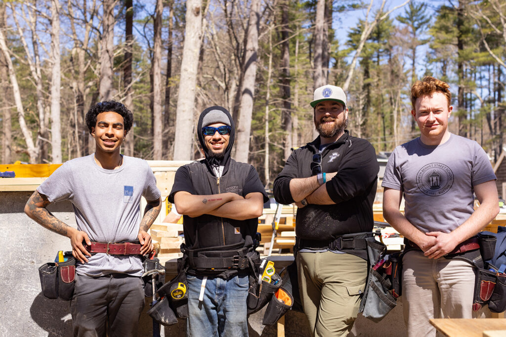 Carpentry students and instructor stand in a line