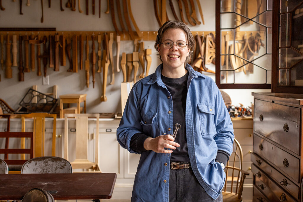 Juliana holding a set of dividers in the Furniture Making space