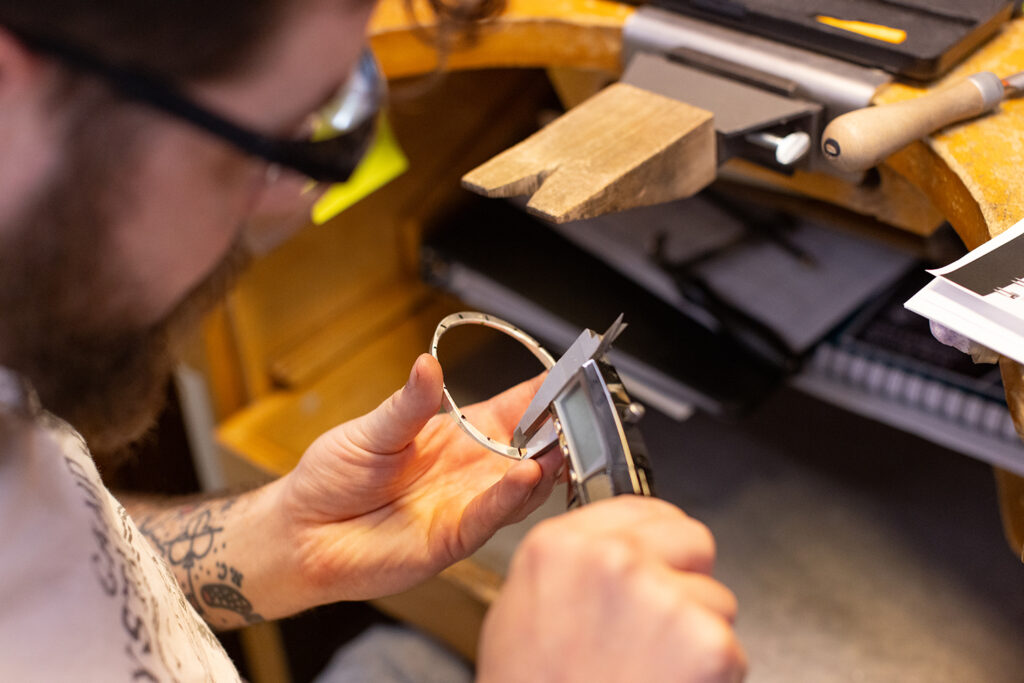 Jewelry making student measuring his bracelet