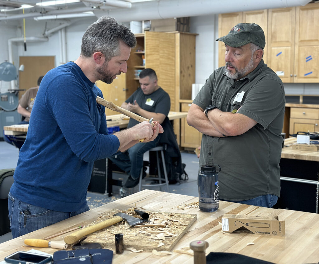 Brennan teaching a spoon carving student