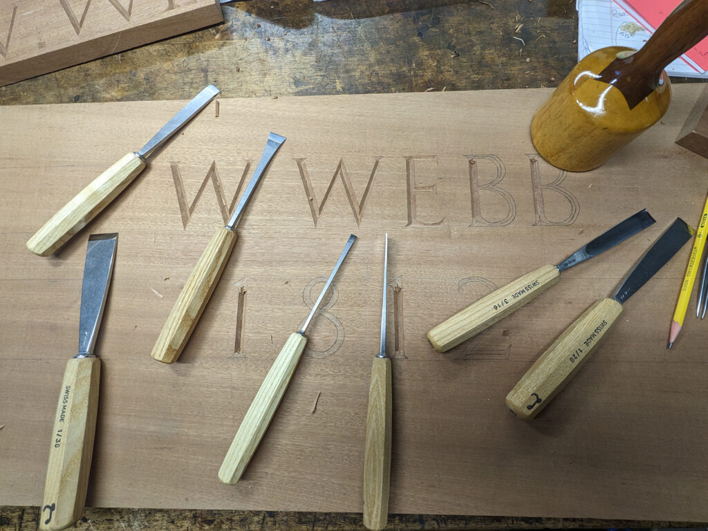 Practicing carving the letters for Captain Webb