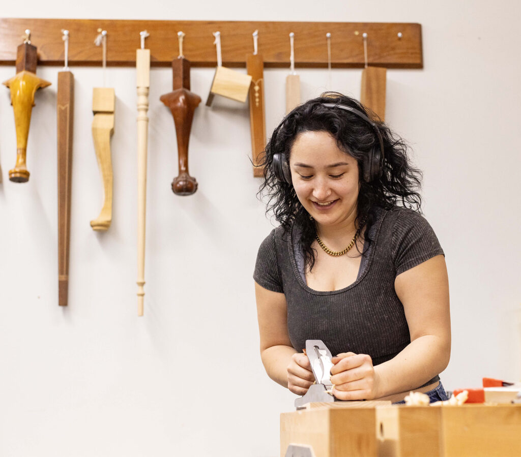 Woodworking student using a handplane