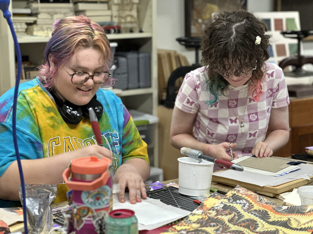 Bookbinding Teen Intensive students glueing covers