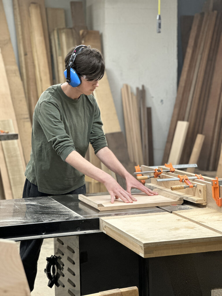 Woodworking Teen Intensive student working at the table saw