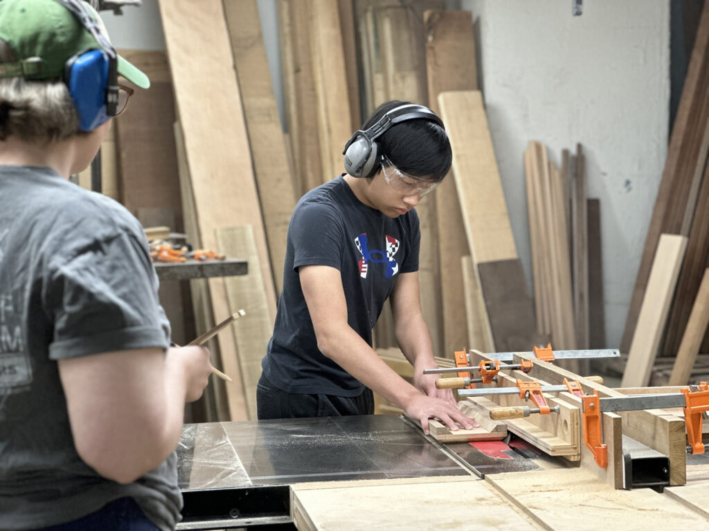Woodworking Teen Intensive student working at the table saw
