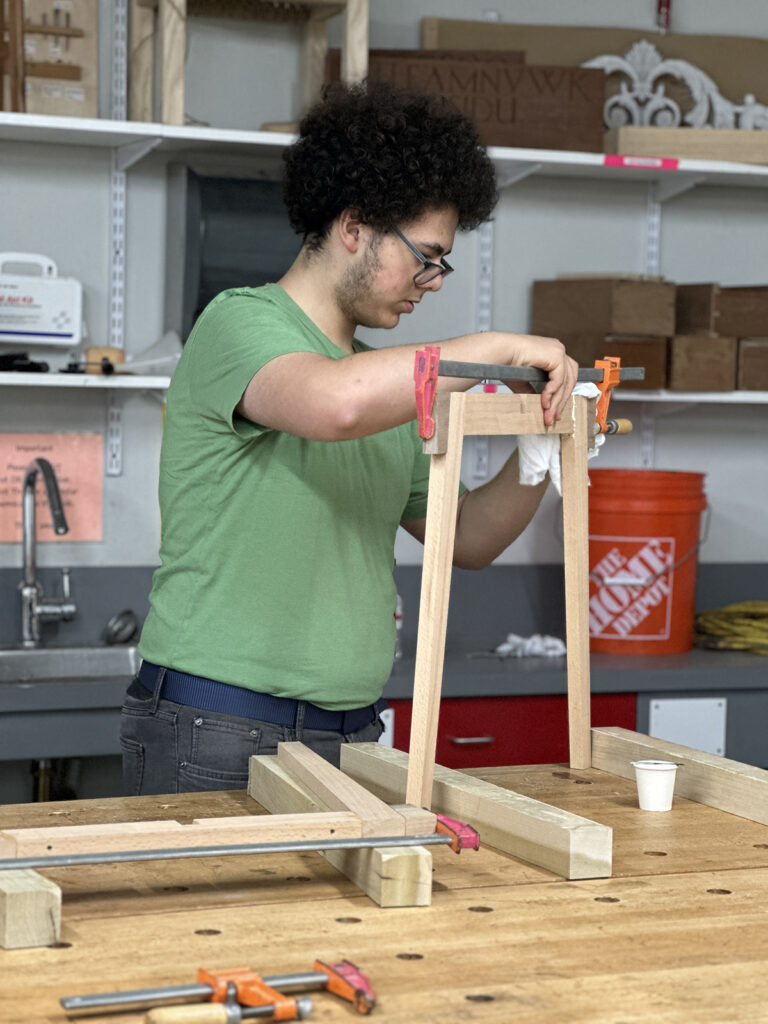 Woodworking Teen Intensive student glueing up table legs