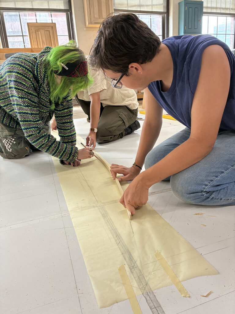 Peter helps measure a section of the timber frame