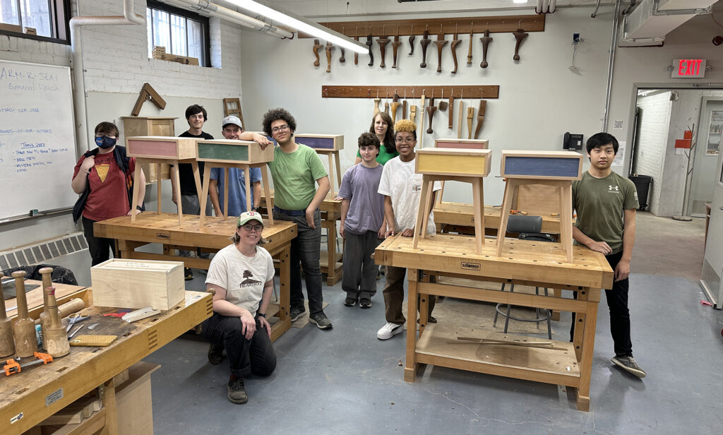 Woodworking intensive students with their finished tables