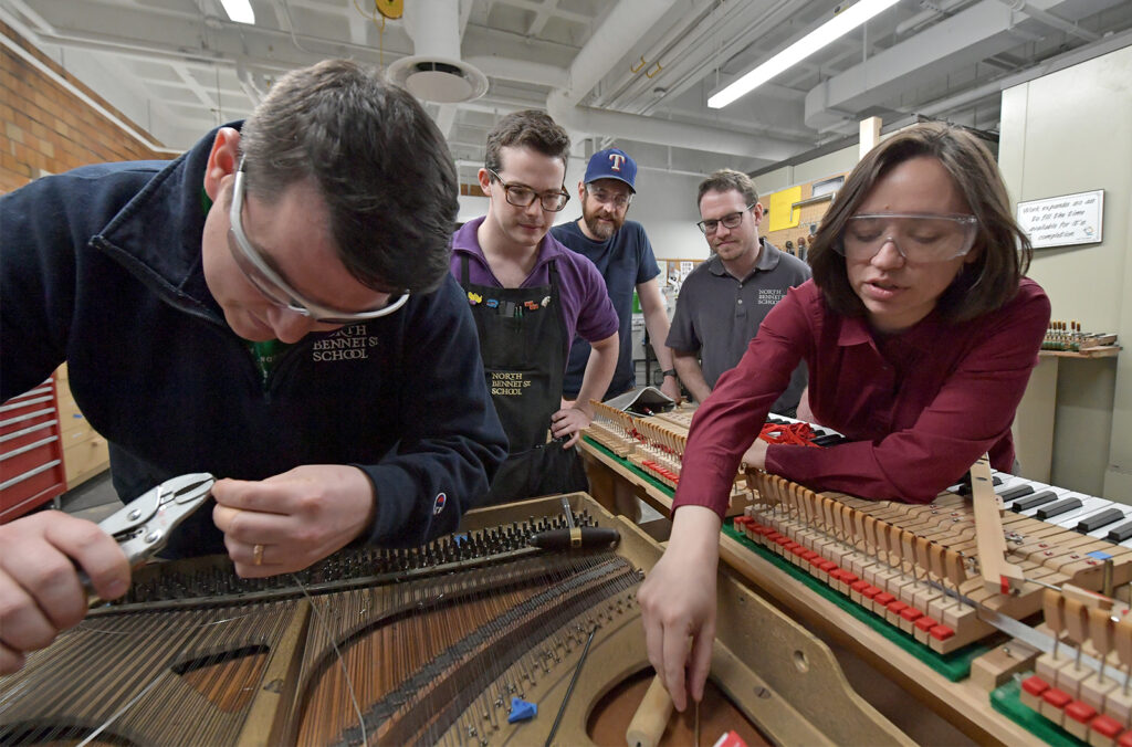 Emily Townsend (right) working on stringing with Basic Piano Technology students