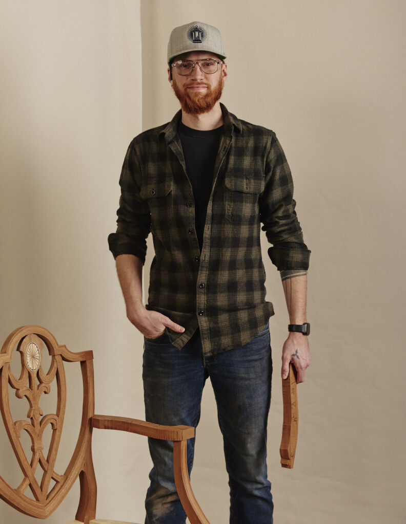 Kolin Schmidt standing next to a shield-back chair he made