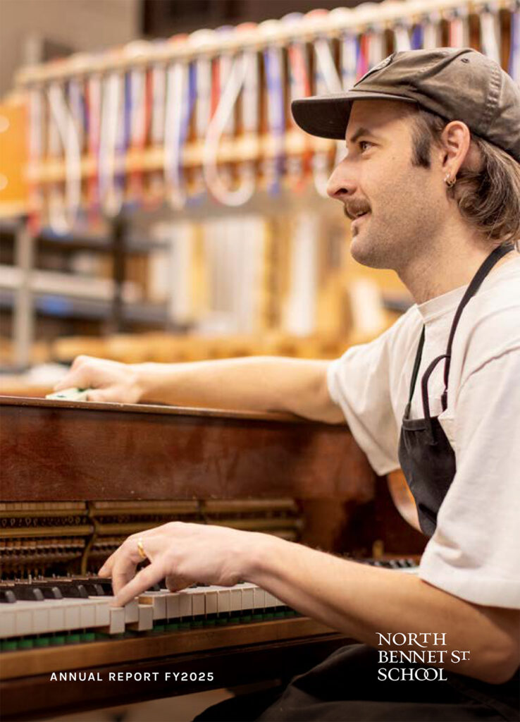 Cover of Annual Report showing a piano technology student tuning a piano