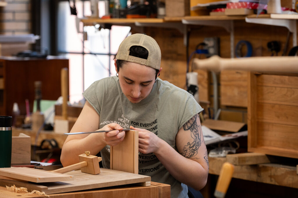 Woodworking student cutting dovetails