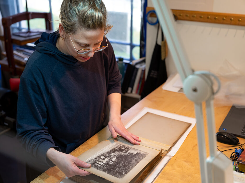 Current von Clemm and Driscoll Family Fellow Yaara Buksbaum at work on a treatment of an early 20th century photo album, Wheel About the Hub.